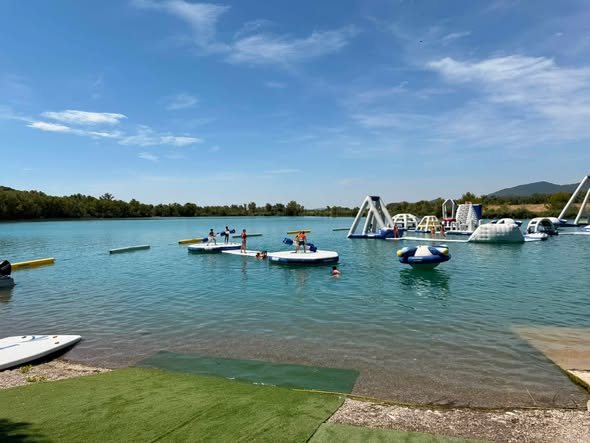 Les jeux gonflables flottant sur le lac des Buissonnades, sous un grand ciel bleu