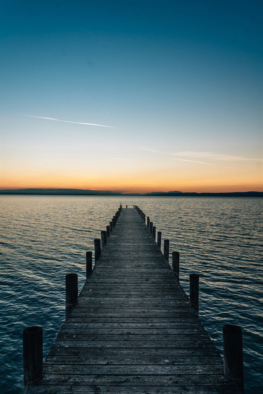 Ponton de bois sur l’eau au crépuscule, photo d’illustration